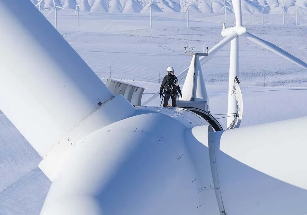Tecnico su una turbina eolica innevata