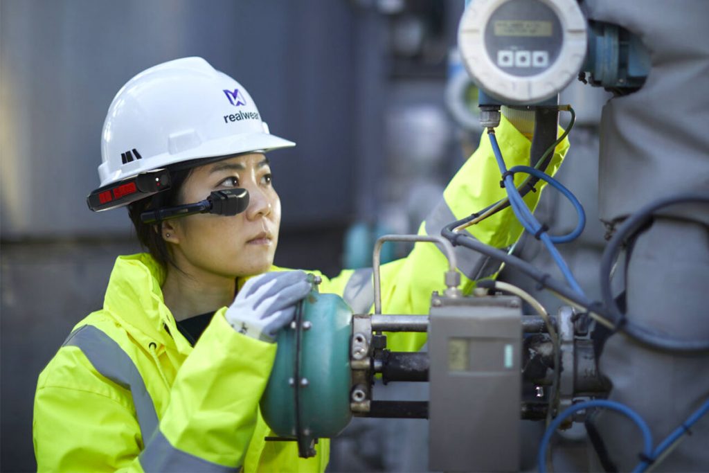 Tecnico industriale con dispositivo RealWear mentre ispeziona un impianto: simbolo di efficienza operativa e sostenibilità ESG