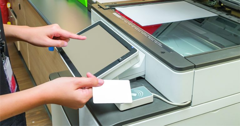 Professionista in studio legale che ritira un documento da stampante tramite badge RFID: esempio di stampa sicura in ambienti riservati
